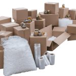 A collection of cardboard boxes, packing tape, bubble wrap, and protective materials illustrating safe packaging essentials.